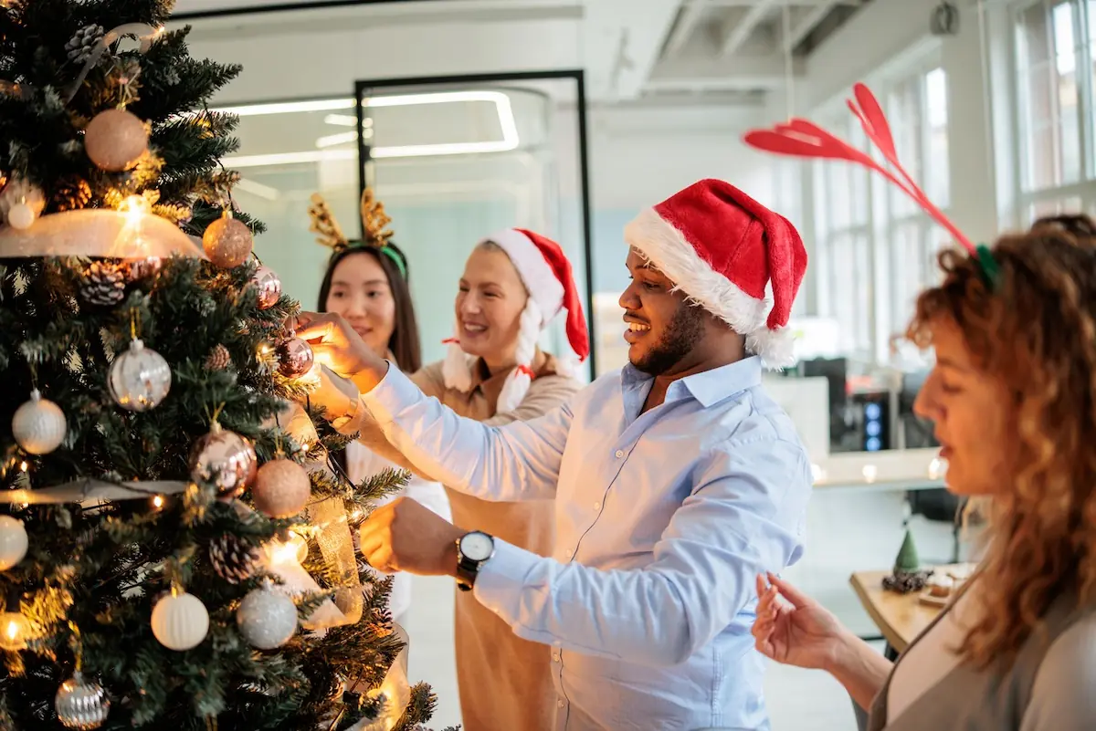 Personas decorando el árbol navideño